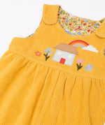 Frugi GOTS 100% organic cotton reversible dungarees in yellow corduroy with a cute highland cottage applique on the front and popper fasteners on the shoulders straps