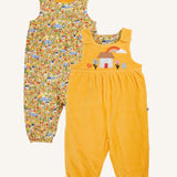 Frugi catrin reversible dungarees bumble yellow highland houses. One side is a bumble yellow corduroy with highland house applique on the front, the other side features an all over highland house print.