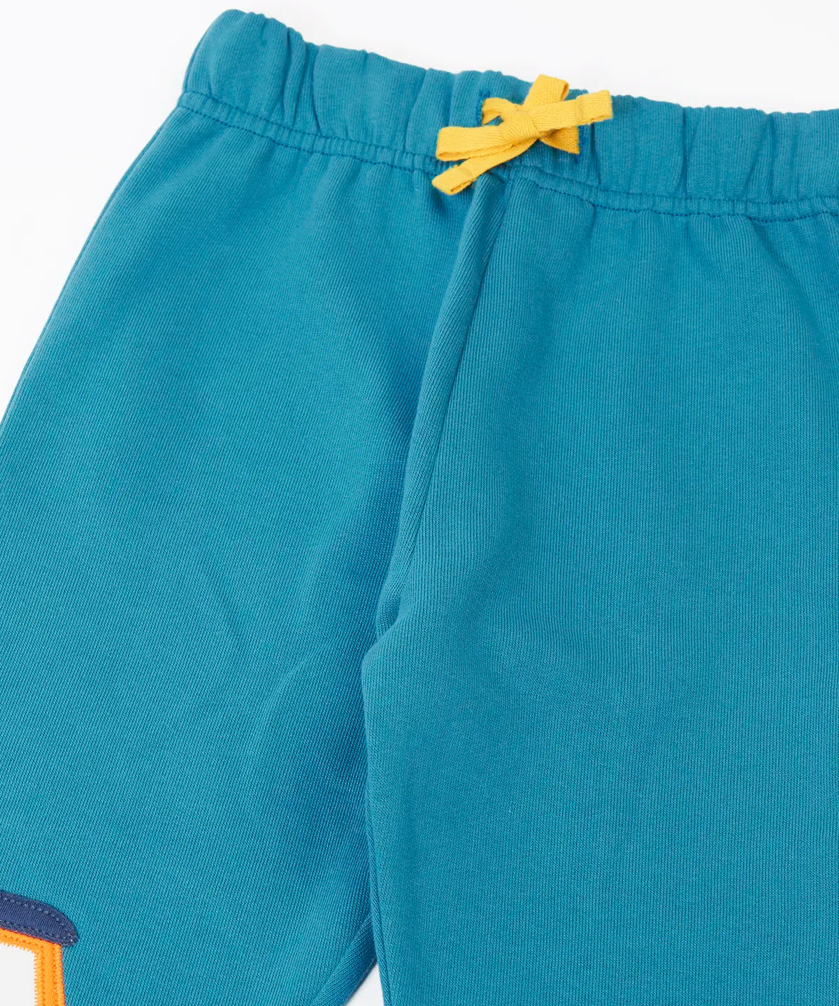 Close up of the Frugi character joggers in boat blue showing the yellow adjustable waist tie on the front.