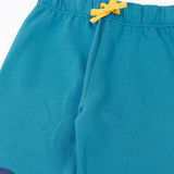 Close up of the Frugi character joggers in boat blue showing the yellow adjustable waist tie on the front.