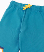 Close up of the Frugi character joggers in boat blue showing the yellow adjustable waist tie on the front.
