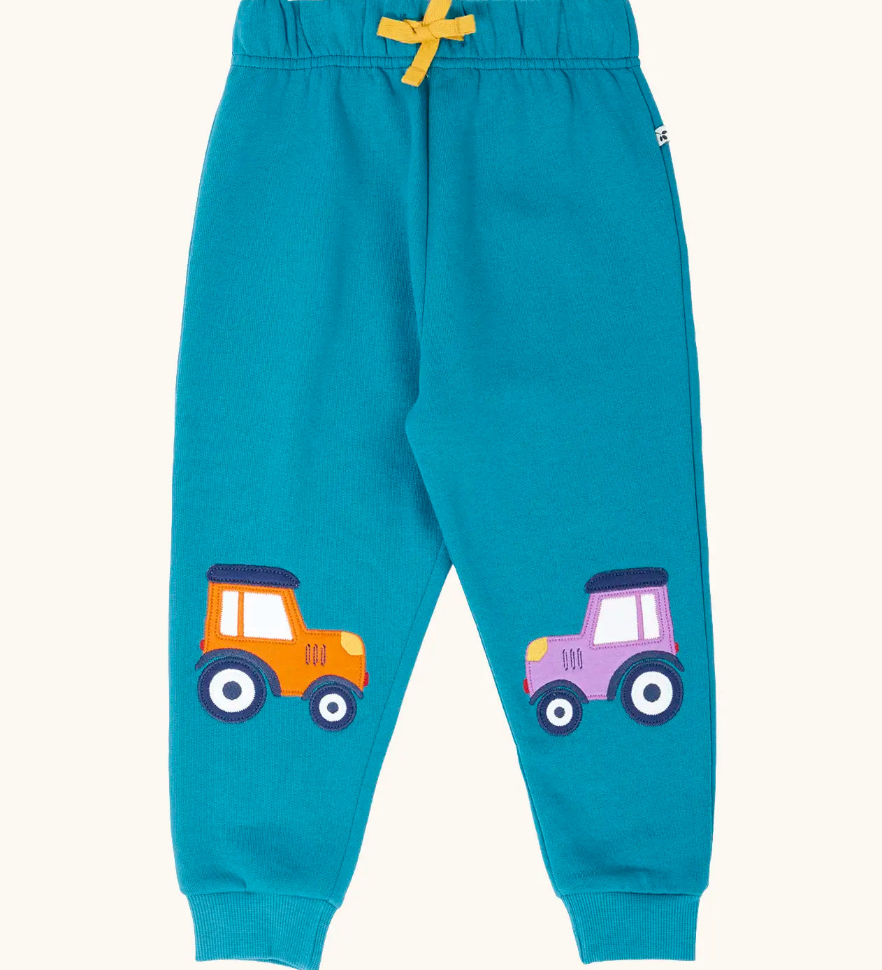 Frugi character joggers in boat blue with tractor appliques on each knee, one orange and one purple. 