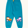 Frugi character joggers in boat blue with tractor appliques on each knee, one orange and one purple. 