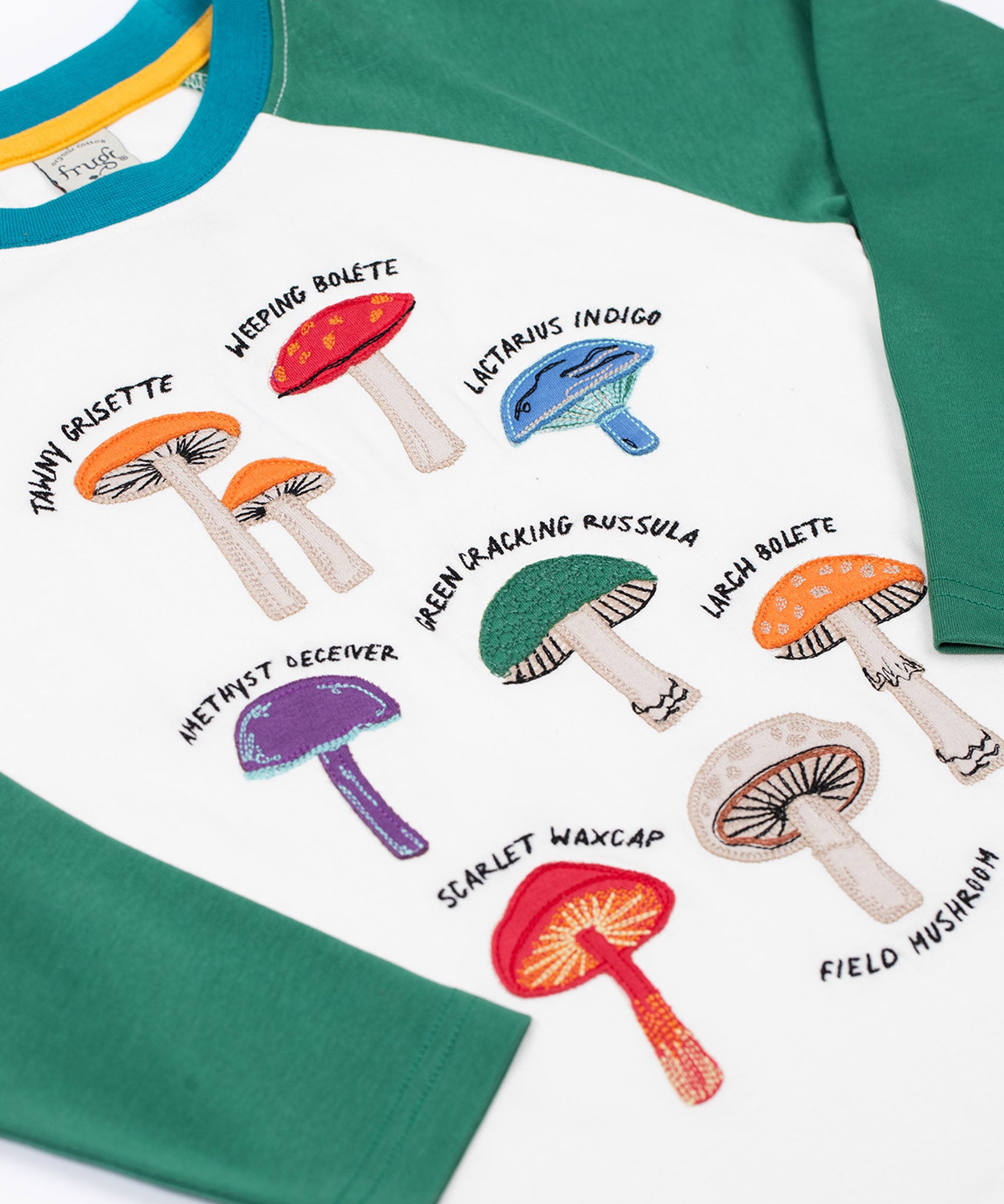 A close up of the mushrooms on teh front of the Frugi Children's Organic Ace Applique Top - White / Mushrooms