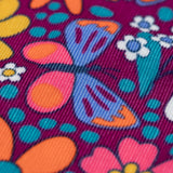 A close up of the detail on the print on the Frugi Organic Cotton Chloe Corduroy Dress for Babies and Toddlers featuring a Retro Floral print design. This dress is a part of a wide range of organic cotton clothing for children available here at Babipur.