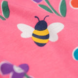 A close up of the bee on the Frugi organic cotton kids Libby leggings with a fun flowers print on a pink background.