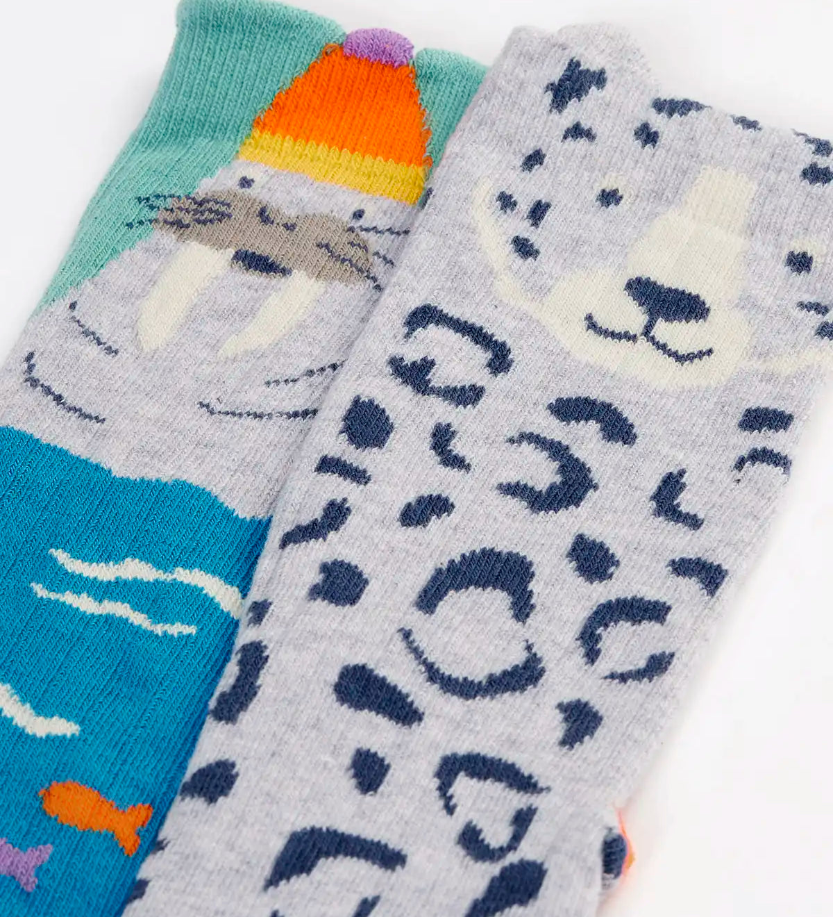 Close up of the Frugi organic cotton character socks 2 pack. One blue pair with a walrus wearing a bobble hat, one pair with a grey leopard.