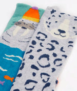 Close up of the Frugi organic cotton character socks 2 pack. One blue pair with a walrus wearing a bobble hat, one pair with a grey leopard.