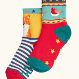 Frugi children's organic cotton grippy socks 2 pack fox fair isle. One pair has navy and white stripes with a fox on a yellow background with green grippy trees on the bottom. One pair has a robin fair isle design with yellow grippy stars on the bottom.