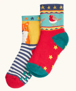Frugi children's organic cotton grippy socks 2 pack fox fair isle. One pair has navy and white stripes with a fox on a yellow background with green grippy trees on the bottom. One pair has a robin fair isle design with yellow grippy stars on the bottom.
