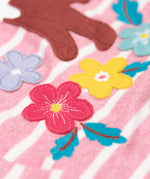A close up of the flower appliques on the Frugi organic cotton archer pine marten applique top pink stripe.
