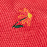 Close up of one of the embroidered flowers on the Frugi children's tabitha rose pink organic cotton corduroy trousers.