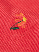 Close up of one of the embroidered flowers on the Frugi children's tabitha rose pink organic cotton corduroy trousers.