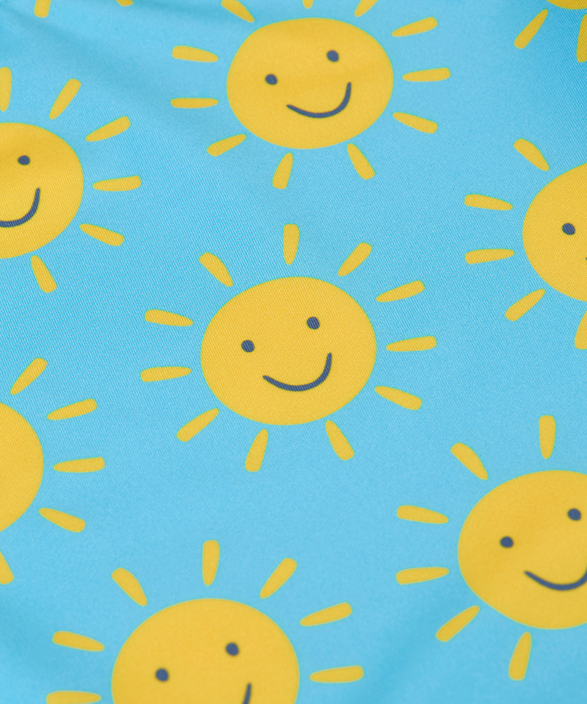 A close up of the smiley sunshine print on the Frugi blue children's tankini. A short sleeved swimwear top with matching brief style bottoms.