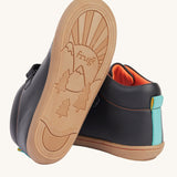 A view of the rubber soles on the Frugi cape stretch children's lace boot in black leather with salamander orange leather lining. 