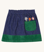 A view of the back of the  Frugi Cara cord children's skirt in ink blue with flower details above a green coloured back pocket. 
