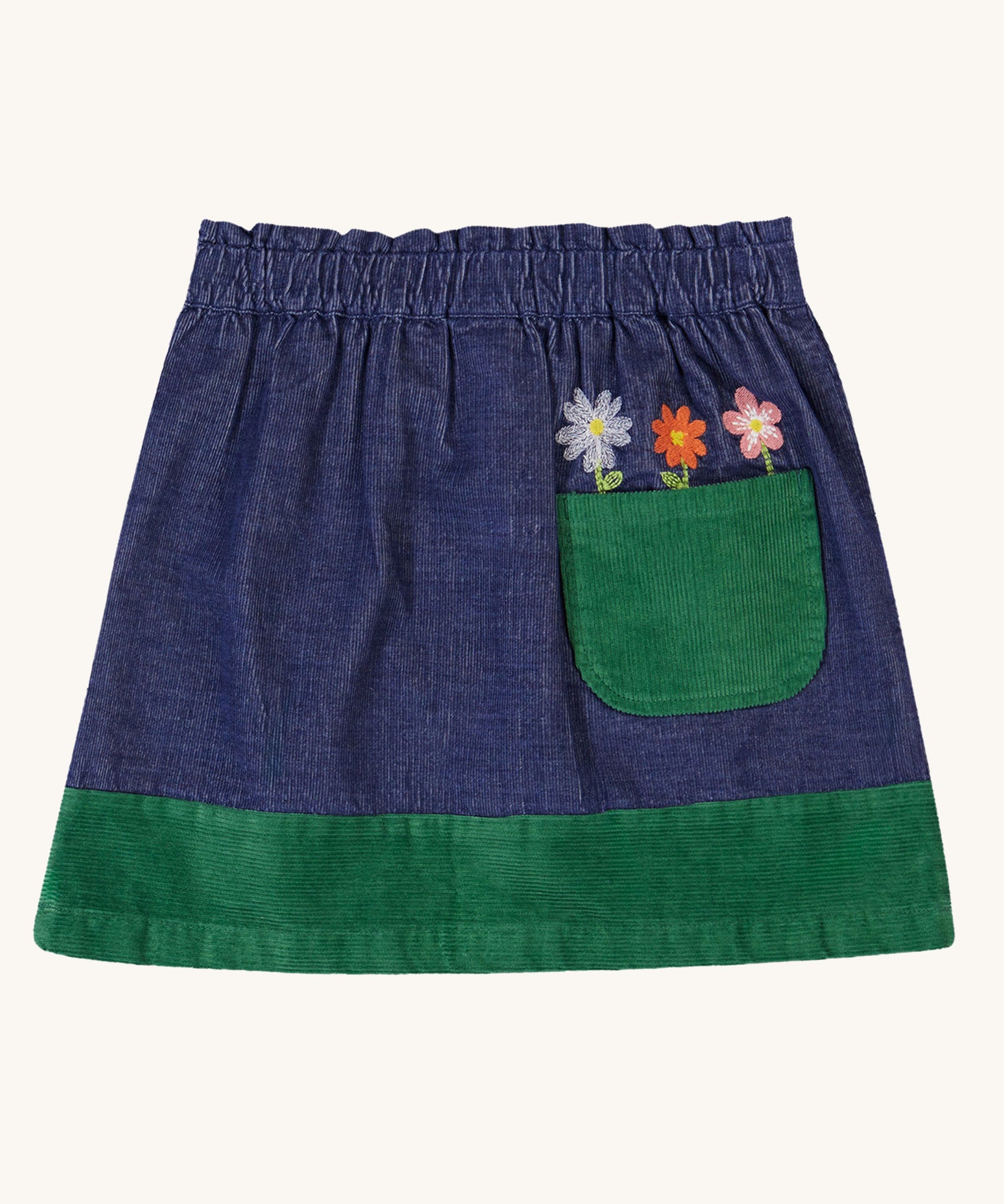 A view of the back of the  Frugi Cara cord children's skirt in ink blue with flower details above a green coloured back pocket. 