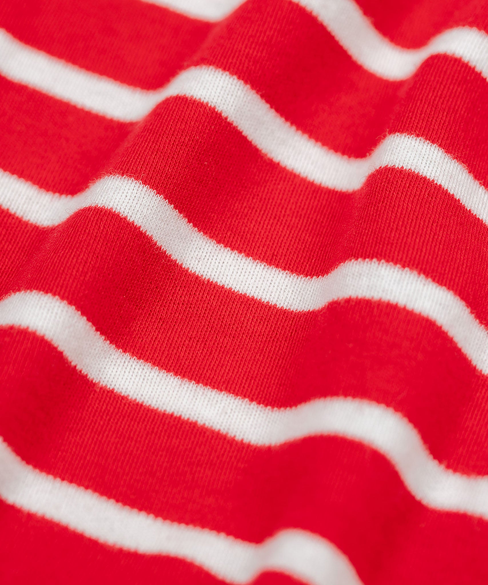 A close up of the material on the Frugi Discovery Organic Cotton Circular Kids' Top with a red and white Breton Stripe.