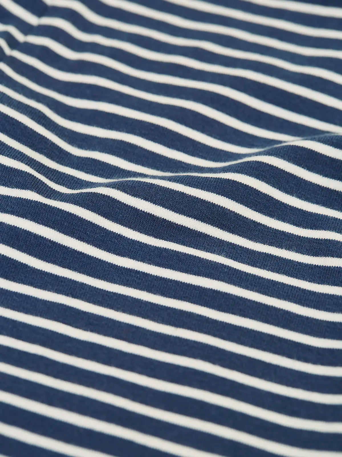 Close up of the material of the Frugi childs organic cotton navy breton stripe leona leggings.