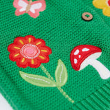 A close up of the flower and mushroom appliques on the front of the Frugi colby clover green coloured knitted organic cotton cardigan.
