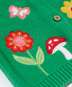 A close up of the flower and mushroom appliques on the front of the Frugi colby clover green coloured knitted organic cotton cardigan.