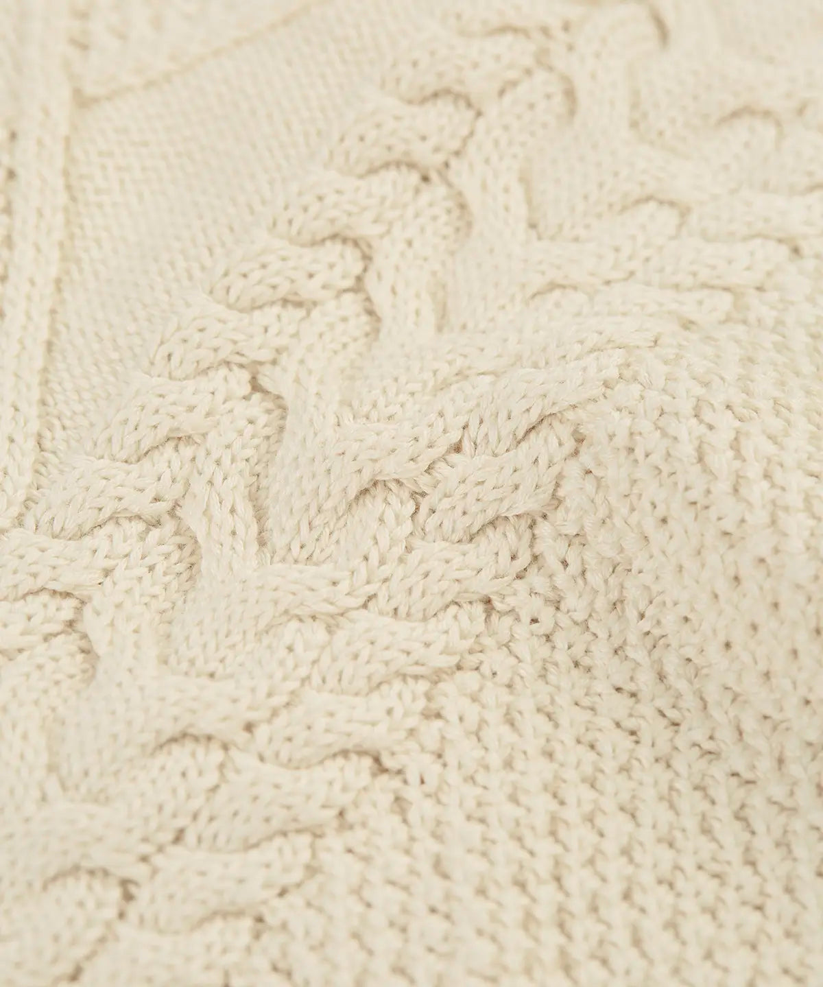 Close up of the natural cream coloured knit on the Frugi clyde cable knit organic cotton jumper.