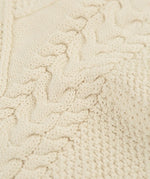 Close up of the natural cream coloured knit on the Frugi clyde cable knit organic cotton jumper.