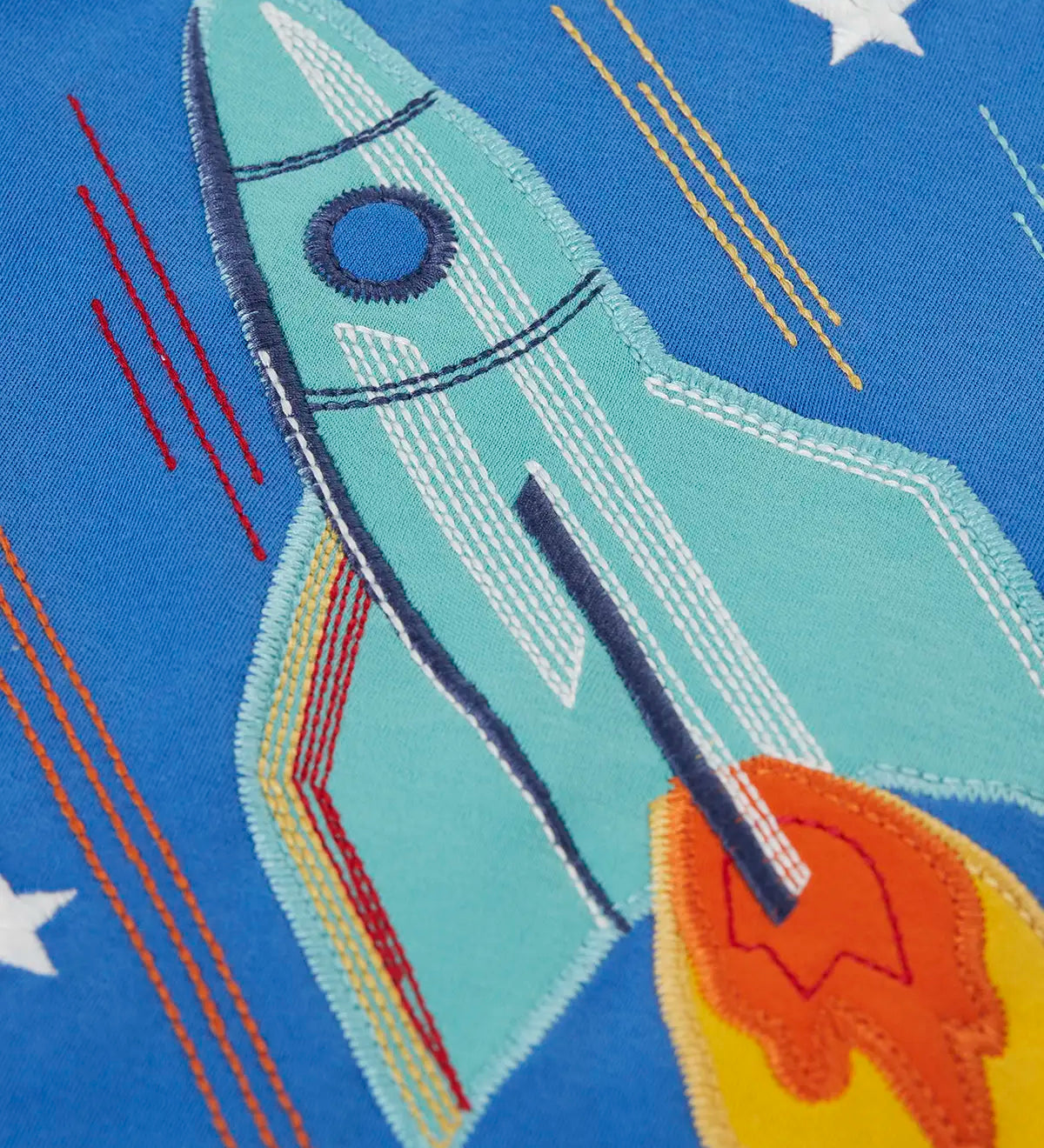 Frugi layered long sleeve top showing close up of a rocket applique on cobalt blue organic cotton fabric