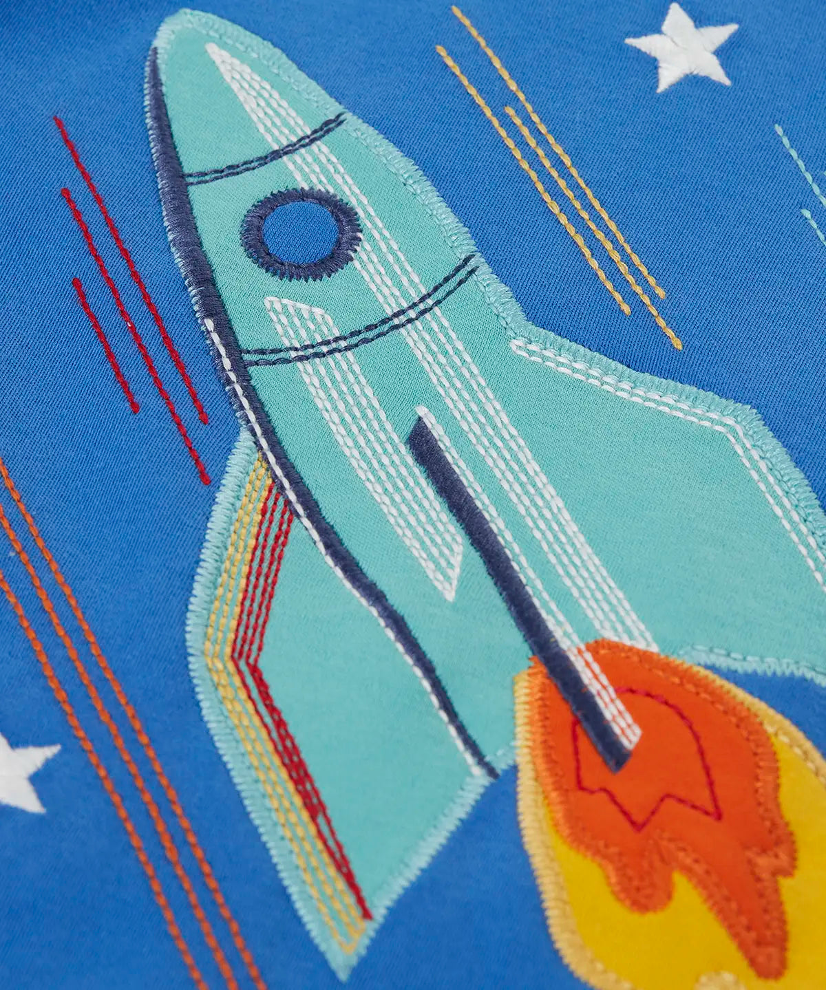 Frugi layered long sleeve top showing close up of a rocket applique on cobalt blue organic cotton fabric