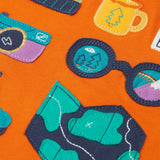 Close up of the details on the adventure themed appliques on the front of the Frugi compass hooded top in orange with turquoise arms and navy hood. 