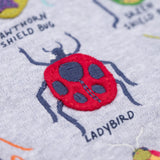 A close up of the ladybird embroidered applique on the Frugi compass hooded long sleeve bug design hoodie top.