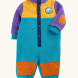 A frugi baby fleece one-piece sleeper in a color-blocked design with purple sleeves and collar, yellow upper chest, teal body, and orange patch details