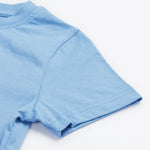 Close up of the Frugi kids cornflower blue chicken t-shirt. Showing short sleeve detail on light blue organic cotton fabric