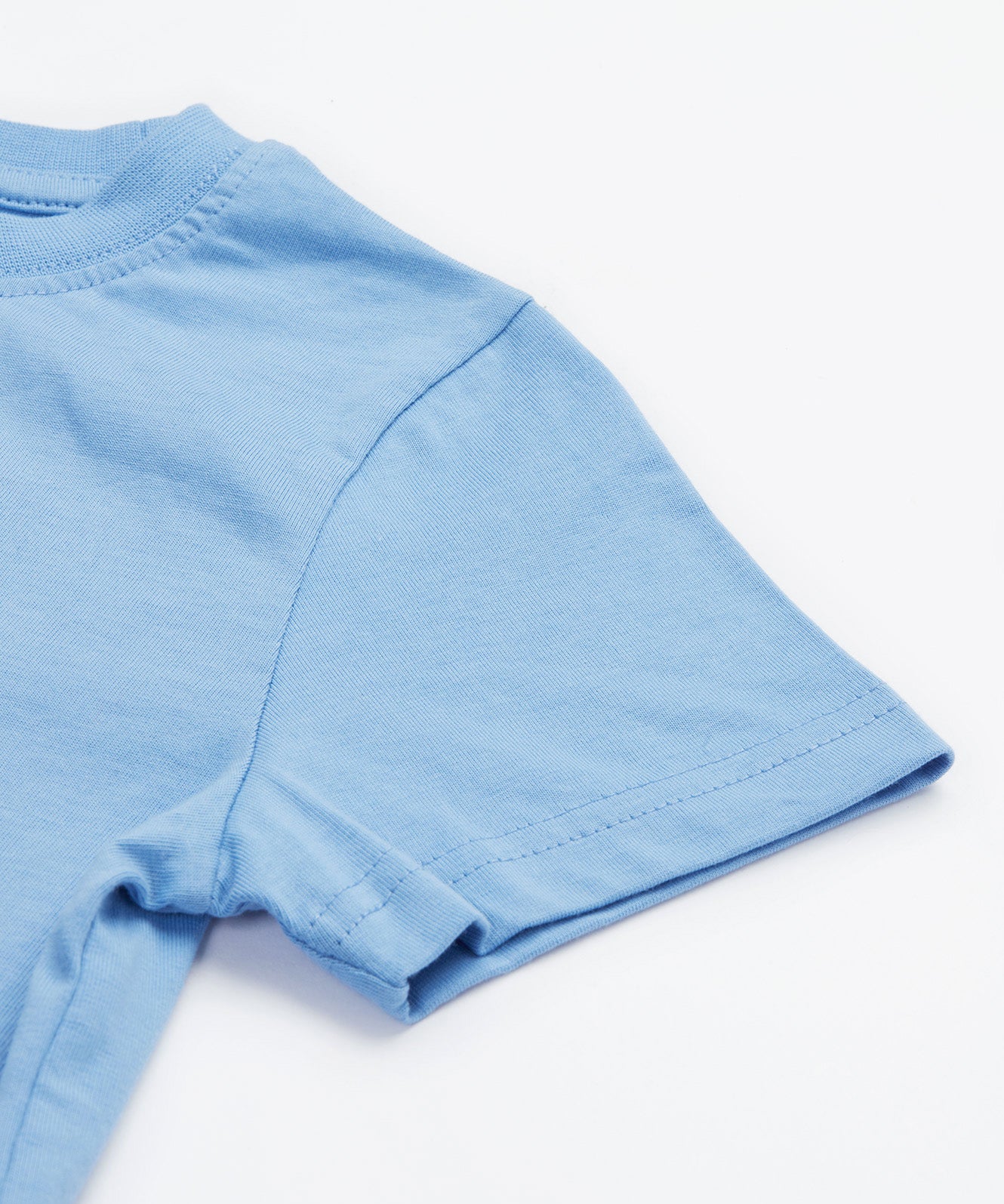Close up of the Frugi kids cornflower blue chicken t-shirt. Showing short sleeve detail on light blue organic cotton fabric