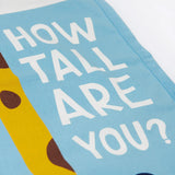 A closeup of the Frugi organic cotton wall decor height chart for kids, reading How tall are you?' in white Frugi font.