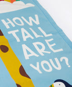 A closeup of the Frugi organic cotton wall decor height chart for kids, reading How tall are you?' in white Frugi font.