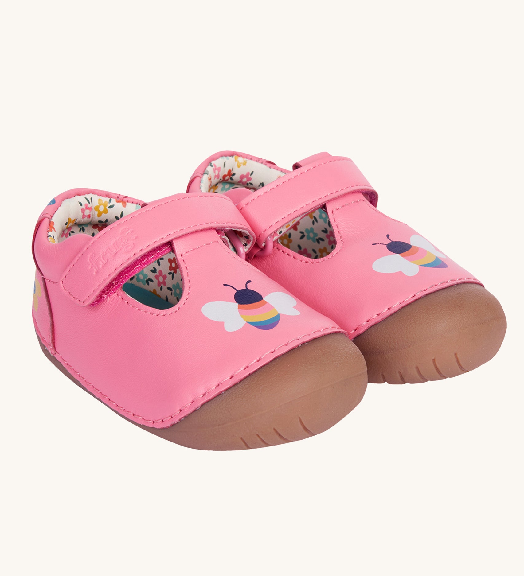 Frugi pink cove first walker t-bar style leather baby shoes with a bee and tulip design. The shoes have a floral patterned lining. 