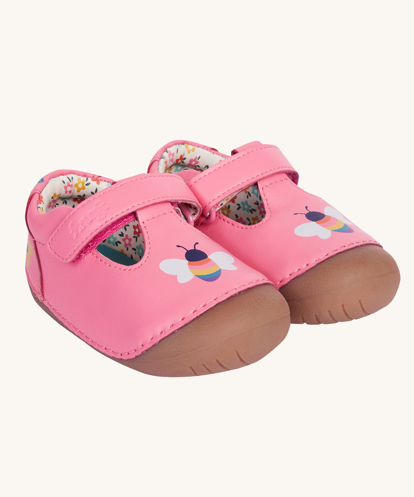 Frugi pink cove first walker t-bar style leather baby shoes with a bee and tulip design. The shoes have a floral patterned lining. 