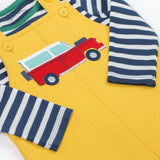 A close up of the Frugi kids coverack dungaree outfit in bumblebee/vehicle showing the red vehicle applique and button fastener detail with the striped top underneath