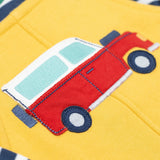 A close up of the Frugi kids coverack dungaree outfit in bumblebee/vehicle showing the red vehicle applique detail on yellow organic cotton fabric.