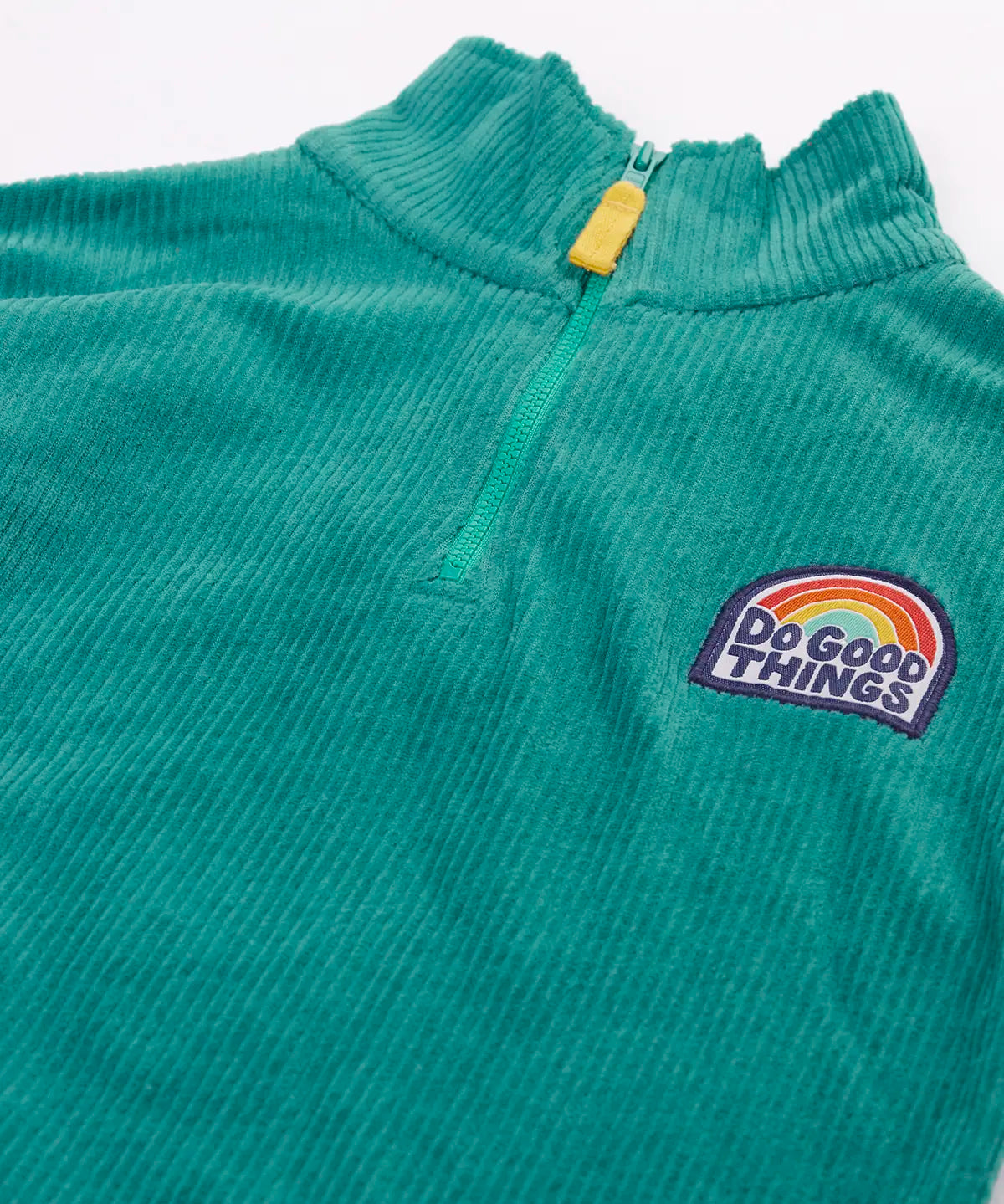 Close up of the half zip on the front of the Frugi Croft organic cord half zip jumper in hut green.