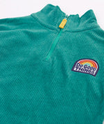Close up of the half zip on the front of the Frugi Croft organic cord half zip jumper in hut green.
