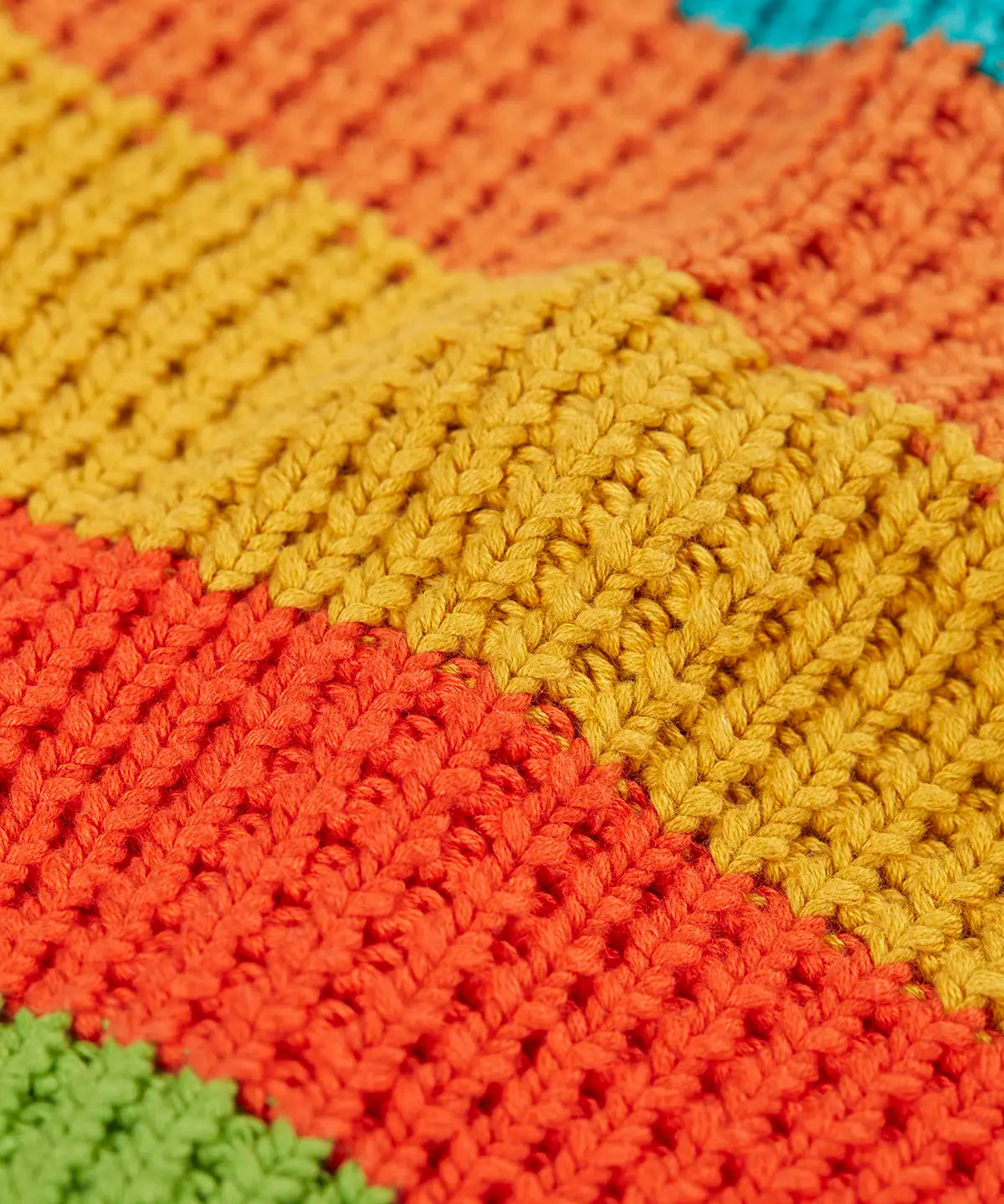 Close up of the organic cotton knit on the Frugi cuddly highland wide stripe rainbow cardigan.