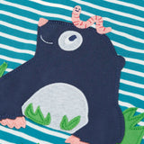 Close up of the mole applique with a worm on it's head on the front of the Frugi discovery long sleeve top in a boat blue Breton stripe.