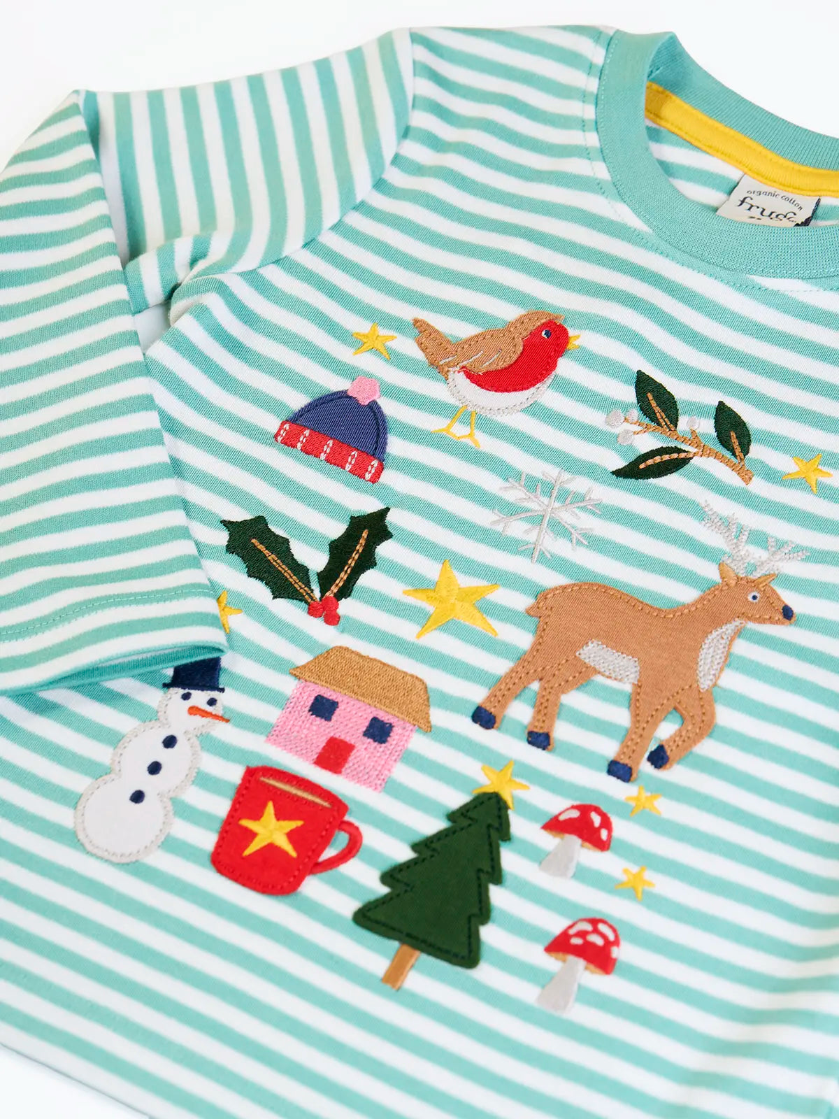 Close up of the front of the Frugi discovery organic cotton long sleeved top in miss green stripe with winter appliques. Robin, mistletoe, bobble hat, reindeer, holly, house, hot chocolate, snowman, tree, mushroom and stars. 