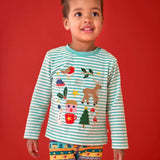A young child wearing a Frugi organic cotton long-sleeve striped top with a festive Christmas-themed applique design and knitted fair isle leggings.