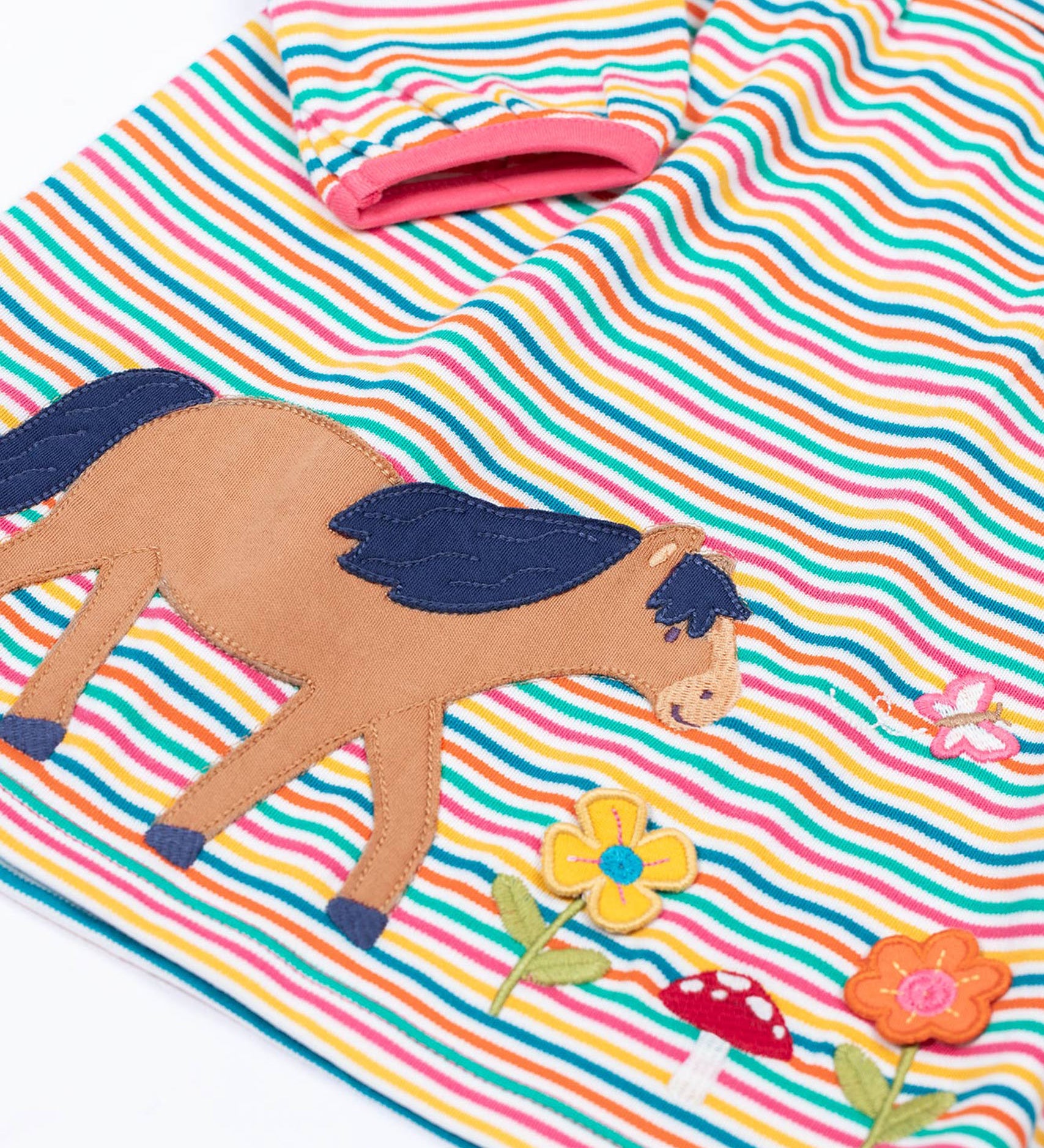 A close up of the horse applique on the front of the Frugi dolcie organic cotton child's dress. 