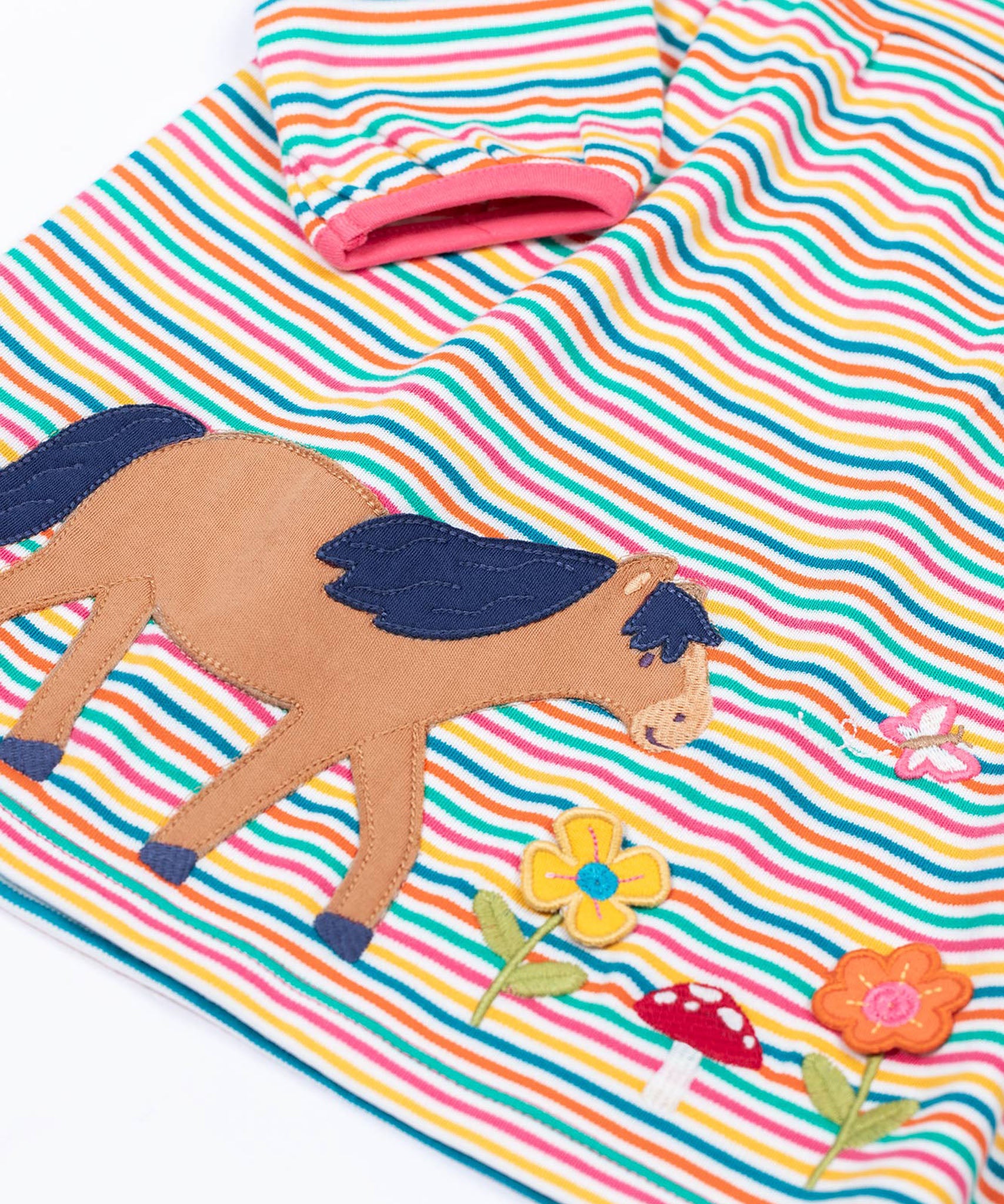 A close up of the horse applique on the front of the Frugi dolcie organic cotton child's dress. 