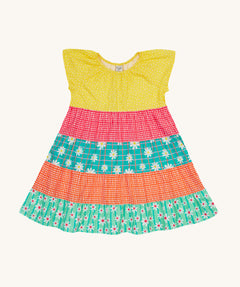Frugi Dorothy Twirly Dress laid flat, with a  Rainbow Hotchpotch print, a patchwork type design featuring yellow, red orange and green patterns with daisies.