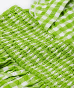 Close up of the Frugi kids macaw gingham birds dress. Showing the elasticated waist band on green and white gingham organic cotton fabric.